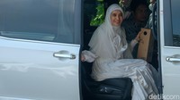 Aktris Dhini Aminarti menaiki mobil sebelum meninggalkan lokasi resepsi. Prosesi akad nikah diselenggarakan sejak Jumat (29/7), sedangkan resepsi digelar sejak beberapa sesi sejak Jumat malam hingga hari ini.