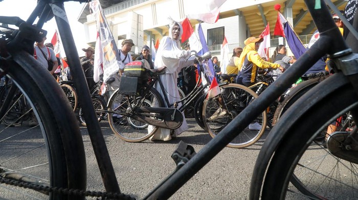 Peserta berkostum unik mengikuti kegiatan Parade Sepeda Tua Nusantara di Gor Jayabaya, Kota Kediri, Jawa Timur, Minggu (31/7/2022). Kegiatan bersepeda sejauh 17 kilometer menggunakan sepeda tua dan berkostum unik tersebut diikuti oleh sedikitnya 5 ribu peserta dari penjuru nusantara. ANTARA FOTO/Prasetia Fauzani/foc.