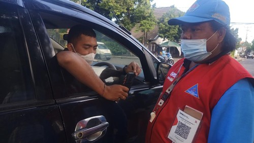 Salah satu pengunjung Lapangan Puputan Badung, Denpasar, Bali, scan barcode pada rompi petugas parkir untuk pembayaran cahsless, Minggu (31/7/2022).