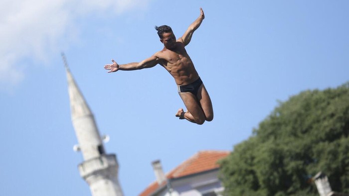 A diver jumps from the Old Bridge during the 456th traditional annual high diving competition in Mostar, Bosnia, Sunday, July 31, 2022. A total of 31 divers from Bosnia and region leapt from the 23-meter-high bridge into the Neretva River. (AP Photo/Armin Durgut)
