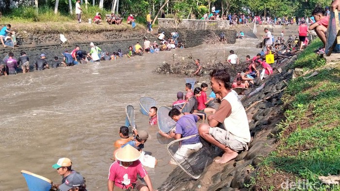 bersih sungai Warga Purworejo bersih sungai dan mencari ikan bersama, Senin (1/8/2022).