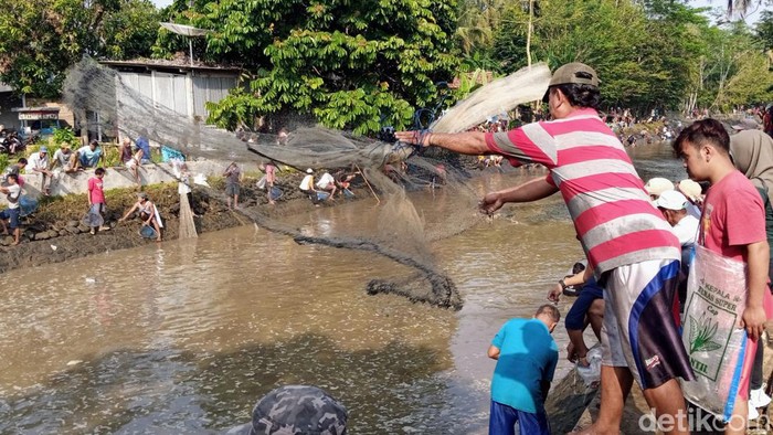 Warga Purworejo mencari ikan dan bersih sungai, Senin (1/8/2022).