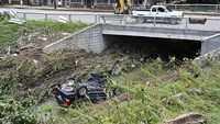 Sebuah mobil terseret arus banjir hingga ke sungai. AP Photo/Timothy D Easley.