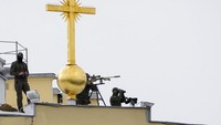 Petugas Layanan Keamanan Federal Rusia mengawasi dari ketinggian saat Presiden Vladimir Putin dan pejabat tinggi militer Rusia lainnya menghadiri parade militer selama perayaan Hari Angkatan Laut di Sungai Neva di St.Petersburg. (AP/Dmitri Lovetsky)