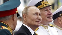 Presiden Rusia Vladimir Putin (tengah), Menteri Pertahanan Rusia Sergei Shoigu (kiri), dan Panglima Angkatan Laut Rusia Laksamana Nikolai Yevmenov menyaksikan parade militer selama perayaan Hari Angkatan Laut. (AP/Mikhail Klimentyev)