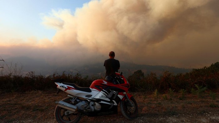 Firefighters patrol a burned area from a wildfire in Venda do Pinheiro in Mafra, Portugal, July 31, 2022. REUTERS/Pedro Nunes