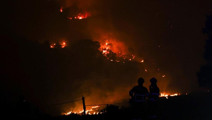 Firefighters patrol a burned area from a wildfire in Venda do Pinheiro in Mafra, Portugal, July 31, 2022. REUTERS/Pedro Nunes