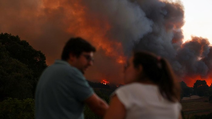 Firefighters patrol a burned area from a wildfire in Venda do Pinheiro in Mafra, Portugal, July 31, 2022. REUTERS/Pedro Nunes