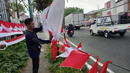 Demi bisa membayar uang kuliah tunggal Rizal Hidayat rela  menjajakan bendera di Bypass Ir Soekarno, Kediri, Tabanan, Senin (1/8/2022) sore.