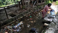 Ada juga warga yang mencuci di saluran air dengan sampah berserakan.