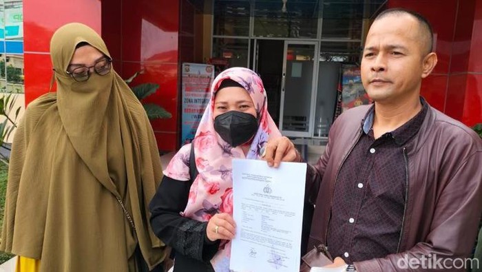 Nova Yunita, wanita yang mengaku istri sah Bupati Banyuasin Askolani didampingi kuasa hukumnya saat melapor ke Polda Sumsel.