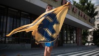 Seorang pemuda memegang bendera Batalyon Azov selama rapat umum untuk mendukung Anggota Batalyon Azov pada Senin (01/08/2022) di Zhytomyr, Ukraina.