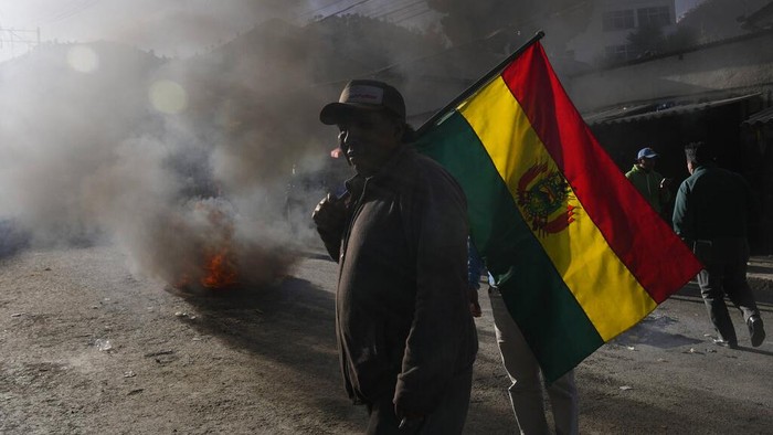 Bolivia Coca Clash A coca leaf farmer protests near a burning barricade during the clashes with police near the coca market in La Paz, Bolivia, Monday, Aug. 1, 2022. Anti-government coca farmers are protesting against a new coca leaf market in La Paz. (AP Photo/Juan Karita)