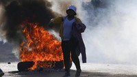 Seorang petani perempuan ikut protes di dekat barikade yang terbakar. Selama ini, pasar koka resmi berada di dua tempat. Pemerintah berencana membuka pasar ketiga untuk mendorong harga yang lebih kompetitif namun ditolak petani.