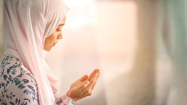 Ilustrasi Niat Mandi Wajib Setelah Haid Young beautiful muslim women open palm, peaceful praying in mosque.