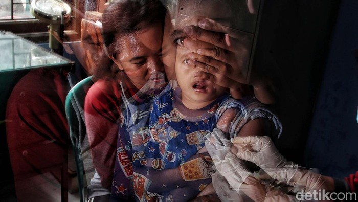 Petugas memberikan imunisasi di kawasan RW 04 Semper Barat, Selasa (2/8). Kegiatan ini merupakan rangkaiam kegiatan Bulan Imunisasi Anak Nasional (BIAN) selama bulan Agustus.