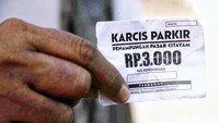 Petugas menujukkan karcis masuk di penampungan sementara Pasar Citayam. Warga yang berkunjung dikenakan biaya parkir Rp 3000.