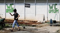 Pengunjung melintas di depan WC umum pasar. 