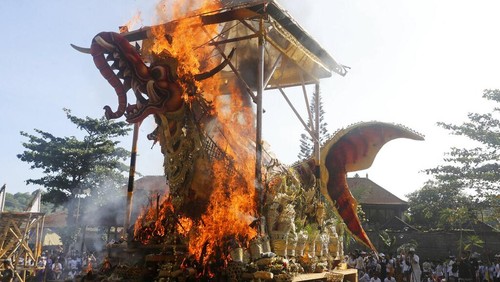 Fire engulfs a giant effigy of a mythical animal containing the remains of 117 people during a traditional mass cremation called ngaben on Friday, July 29, 2022, in Padangbai, Bali, Indonesia. The previously buried remains were dug up and placed in a temporary shrine before being cremated. Balinese believe that cremating the dead liberates their souls, allowing them to enter the higher world to reincarnate into better beings. (AP Photo/Firdia Lisnawati)