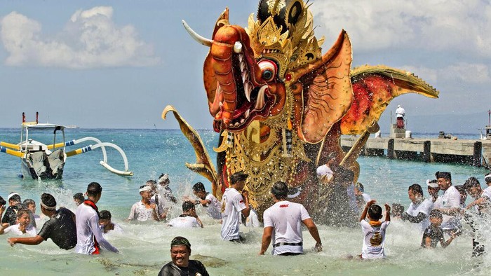 Fire engulfs a giant effigy of a mythical animal containing the remains of 117 people during a traditional mass cremation called 