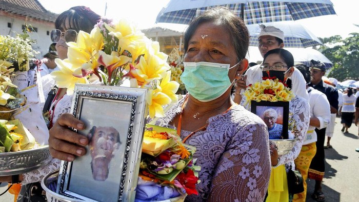 Fire engulfs a giant effigy of a mythical animal containing the remains of 117 people during a traditional mass cremation called 