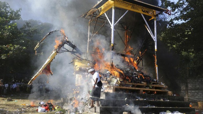 Fire engulfs a giant effigy of a mythical animal containing the remains of 117 people during a traditional mass cremation called 