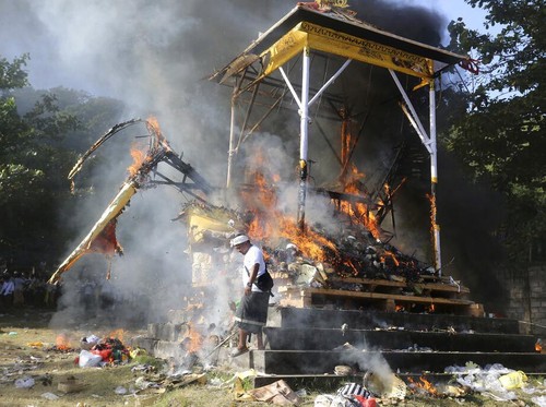 Fire engulfs a giant effigy of a mythical animal containing the remains of 117 people during a traditional mass cremation called ngaben on Friday, July 29, 2022, in Padangbai, Bali, Indonesia. The previously buried remains were dug up and placed in a temporary shrine before being cremated. Balinese believe that cremating the dead liberates their souls, allowing them to enter the higher world to reincarnate into better beings. (AP Photo/Firdia Lisnawati)