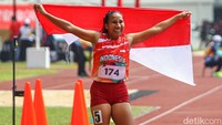 Usai berhasil finis tercepat Ni Made Arianti membawa bendera Merah Putih dan berselebrasi di depan awak media. Foto: Pius Erlangga/detikJateng