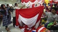 Pengunjung pasar melintas di depan umbul-umbul kemerdekaan di Pasar Senen. Berbagai ukuran umbul-umbul ada di sini.