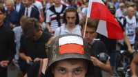 Tak hanya bendera dan suar, seorang warga Polandia ada yang memakai topi besi berlambangkan bendera Polandia.