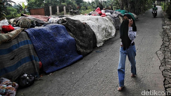 Sejumlah warga melintas di kawasan tumpukan sampah dekat perkampungan Situ Citayam, Depok, Jawa Barat, Senin (1/8). Tumpukan sampah itu dikeranakan warga yang sering buang sampah sembarangan sehingga perkampungannya terlihat jorok dan bau saat melintas.