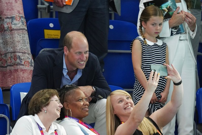 Pangeran William diajak foto selfie bersama penonton yang duduk di depannya. Putri Charlotte seperti sedih tak ikut sesi foto tersebut. (Foto: AP/Kirsty Wigglesworth)