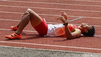Saptoyogo Purnomo membawa bendera Merah Putih setelah berhasil menjadi yang tercepat saat final lari nomor 200 meter putra T37, ASEAN Para Games 2022. (Foto: Pius Erlangga/detikJateng)