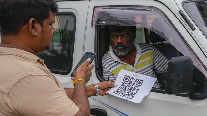 Sri Lanka Mulai Terapkan Kode QR untuk Beli Bensin A worker scans a QR code before pumping gas to a vehicle at a fuel station in Colombo, Sri Lanka, Monday, Aug. 1, 2022. Sri Lanka introduced fuel distribution using the QR code Monday as part of implementing a weekly quota for motorists. (AP Photo/Eranga Jayawardena)
