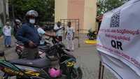 Pengendara sepeda motor menunggu di sebelah spanduk yang bertuliskan hanya kendaraan dengan kode QR yang akan diberikan bahan bakar di SPBU di Kolombo. Negara berpenduduk 22 juta orang itu telah dilumpuhkan oleh krisis ekonomi dalam beberapa bulan terakhir, dengan penduduk menghadapi kekurangan bahan bakar, makanan, dan kebutuhan lainnya.