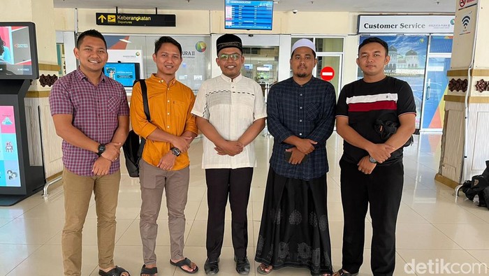 Tengku Munawir Umar (pakai peci hitam dan baju putih) saat berada di bandara. (Foto: Istimewa)