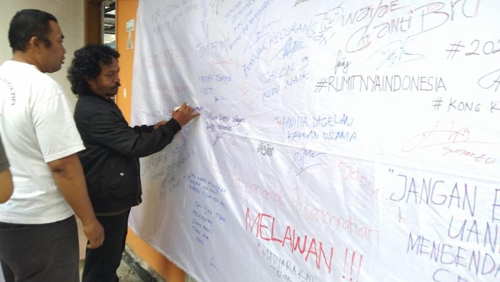 Warga tanda tangan di banner protes PIlkades Kota Batu