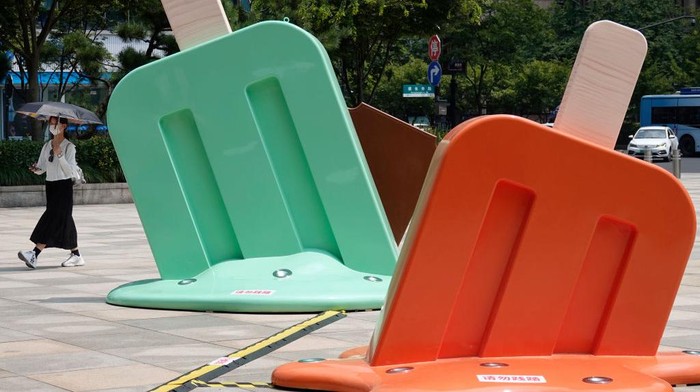 HANGZHOU, CHINA - AUGUST 02: A citizen walks by popsicle-shaped installations outside a shopping mall amid a heat wave on August 2, 2022 in Hangzhou, Zhejiang Province of China. (Photo by Long Wei/VCG via Getty Images)