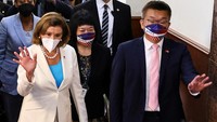 Nancy Pelosi berjalan di samping Wakil Presiden Legislatif Yuan Tsai Chi-chang dan melambaikan tangan ke para wartawan. (Ann Wang/Reuters)