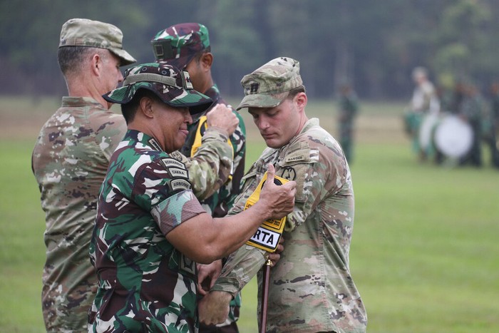 Indonesia US Military Exercises Indonesian Armed Forces Chief Gen. Andika Perkasa, center, and Gen. Charles Flynn, Commanding General of U.S. Army Pacific, left, put on a participant badge to a U.S. soldier during opening ceremony annual joint combat exercises in Baturaja, South Sumatra province, Indonesia, Wednesday, Aug 3, 2022. The United States and Indonesian militaries began annual joint combat exercises Wednesday on Indonesia's Sumatra island, joined for the first time by partner nations, signaling stronger ties amid growing maritime activity by China in the Indo-Pacific region. (AP Photo)