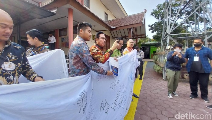 Kuasa Hukum JE terdakwa perkara kekerasan seksual SPI Kota Batu pamer spanduk dukungan siswa untuk terdakwa.