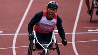 Ekspresi Jaenal Aripin setelah menang pada final balap kursi roda 200 meter putra.