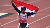 Jaenal Aripin mengibarkan bendera merah putih di belakang pundaknya dan terlihat begitu senang karena berhasil merebut mendali emas.