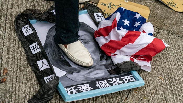 Momen Kunjungan Pelosi, Biang Kerok China Setop Pasok Pasir ke Taiwan Pro-Beijing protesters rip up a US flag after stamping on an image depicting the US House Speaker Nancy Pelosi at a protest outside the US Consulate in Hong Kong on August 3, 2022 after Pelosi arrived in Taiwan late on August 2, 2022 as part of a tour of Asia that has inflamed tensions between the US and China. (Photo by Peter PARKS / AFP) (Photo by PETER PARKS/AFP via Getty Images)