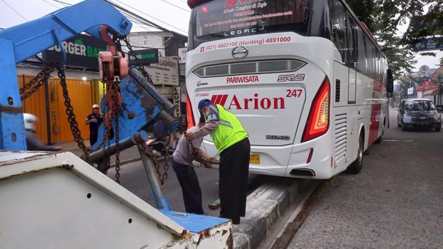 Petugas mengevakuasi bus tersangkut separator di Jl M Yusuf, Depok, Rabu (3/8/2022) pagi.