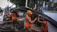 Pekerja menyelesaikan instalasi kabel bawah tanah di Jalan Siliwangi, Depok, Jawa Barat, Selasa (2/8/2022).