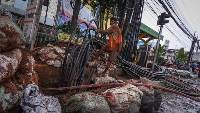 Pekerja menyelesaikan instalasi kabel bawah tanah di Jalan Siliwangi, Depok, Jawa Barat, Selasa (2/8/2022). Pemerintah Kota Depok bersama Asosiasi Penyedia Jaringan Telekomunikasi Indonesia (Apjatel) melakukan pengerjaan relokasi kabel udara ke bawah tanah sepanjang Jalan Siliwangi - Jalan Tole Iskandar untuk estetika di jalan tersebut. ANTARA FOTO/Asprilla Dwi Adha/wsj.