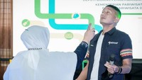 Maaf ya pak, kata Suriani sebelum menyemprotkannya ke wajah Sandiaga. Tapi produk ini aman, nanti mata bapak akan lebih cerah, ujar Suriani sambil terus mempromosikan produknya. (dok. Kemenparekraf)