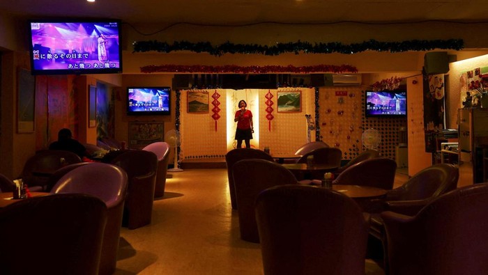 Taiwan Siapkan Tempat Perlindungan Bawah Tanah Antisipasi Serangan Udara A woman sings at a karaoke bar in an underground space that will be used as an air-raid shelter in the event of an attack, beneath a residential building in Taipei, Taiwan July 22, 2022. REUTERS/Ann Wang