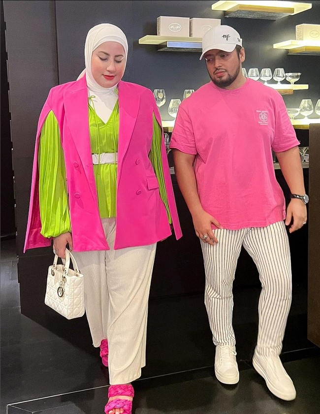 Gaya playful Tasyi Athasyia tampil serasi bareng suami, pakai busana pink dan beige yang diberi percikan warna mencolok lime green. Foto: Instagram/@tasyiiathasyia